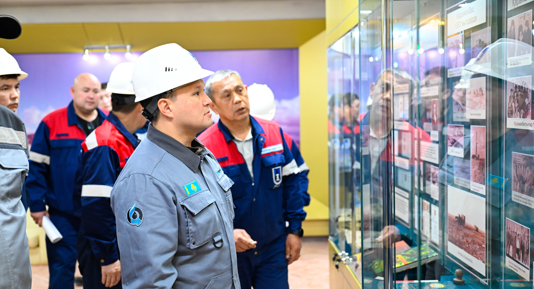 ҚМГ қызметкерлері өнеркәсіптік алаңдағы дисплейді қарап тұр